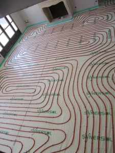 Serpentin de plancher chauffant sur dalles à plots dans une villa en construction